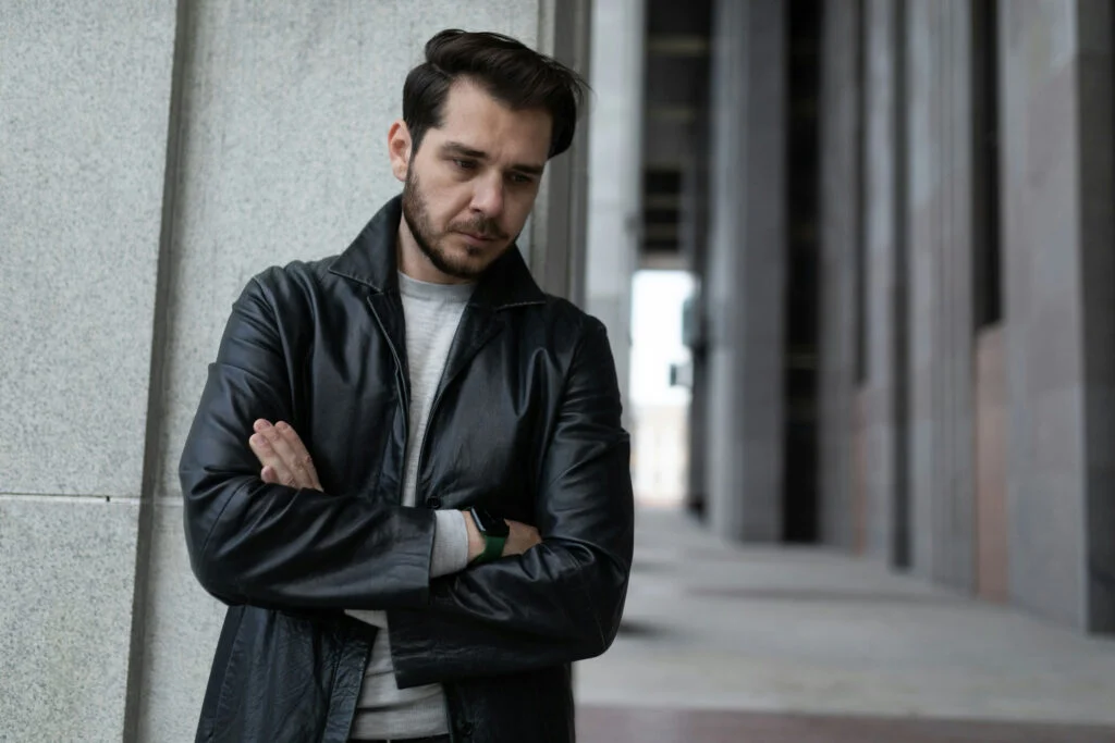 Young man reflecting on seasonal affective disorder and addiction while standing alone outdoors