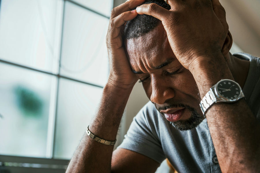 Man struggling with seasonal affective disorder and addiction while experiencing emotional distress indoors