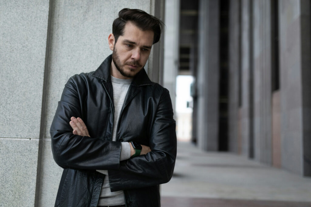 Young man reflecting on seasonal affective disorder and addiction while standing alone outdoors